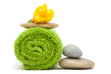 Yellow flower, green towel and river stones - harmony spa concep