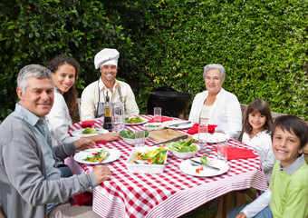 Happy family eating in the garden