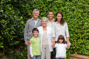 Fototapeta premium Portrait of a happy family looking at the camera in the garden