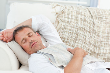 Exhausted man sleeping on the couch at home