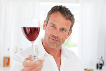 Man with his wineglass in his kitchen