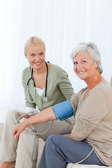 Obraz premium Lovely doctor taking the blood pressure of her patient