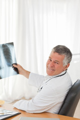 Fototapeta premium A senior doctor looking at the X-ray