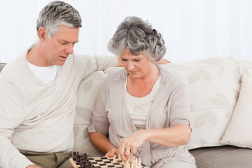 Couple playing chess on their sofa