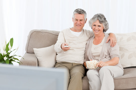 Mature Couple Watching Tv In Their Living Room