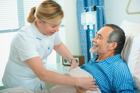 Nurse Cares For A Patient Lying In Bed In Hospital