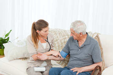 Lovely nurse helping her patient to do exercises