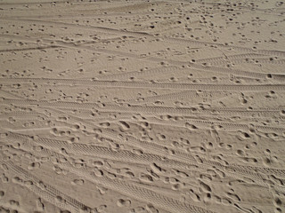 Beach Sand with foot prints and tire tracks