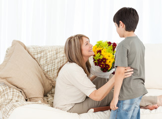 Fototapeta na wymiar Boy offering flowers to his grandmother