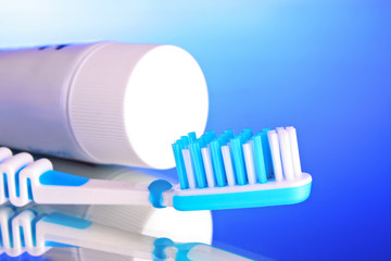 toothpaste and toothbrush on a blue background