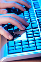 Two hands working on the silver keyboard