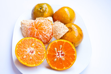 Orange In White plate On a white background.