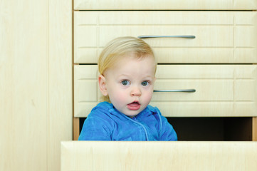 boy in the kitchen cabinet