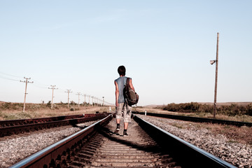Teen boy with problems walking on rail road