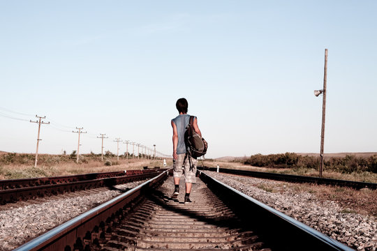 Teen boy with problems walking on rail road