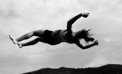 female gymnast jumping in sky