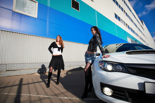 Two beautiful girls friend and stylish white sports car