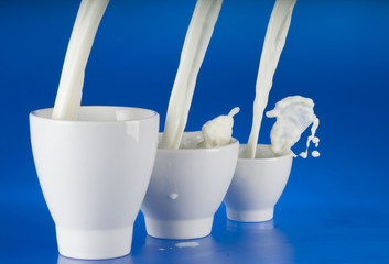 Pouring milk over blue background