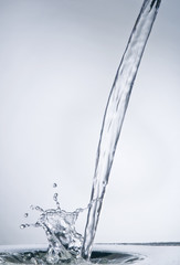 Water stream with splash on blue