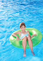 Child sitting on inflatable ring .