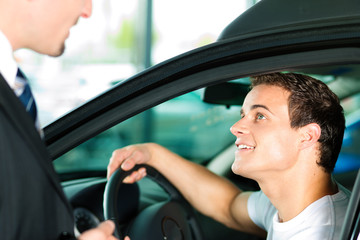 Mann kauft Auto im Autohaus