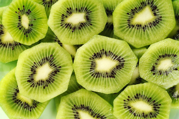 Fresh kiwifruit slices on the green plate.