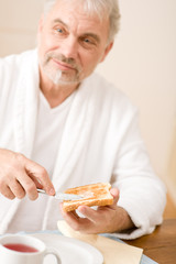 Senior mature man having breakfast, toast