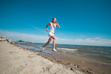 Fototapeta premium Sport woman running in sea coast