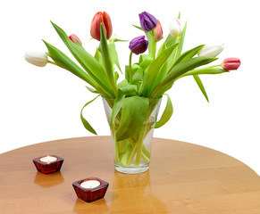 Home table with tulip flowers bouquet and candles