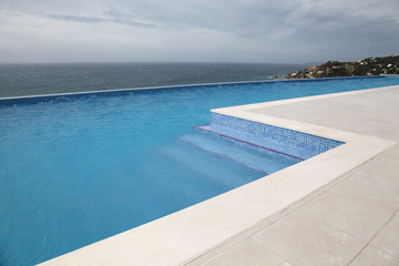Fototapeta na wymiar Modern swimming-pool with view towards the ocean