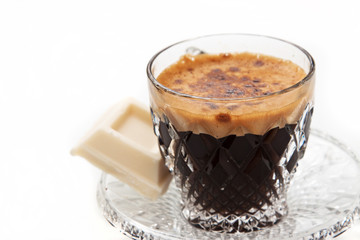Espresso in crystal cup with white chocolate isolated in white