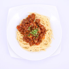 Spaghetti bolognese on a plate decorated with some chives