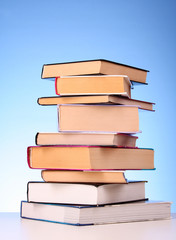 Books pile on the table and yellow background