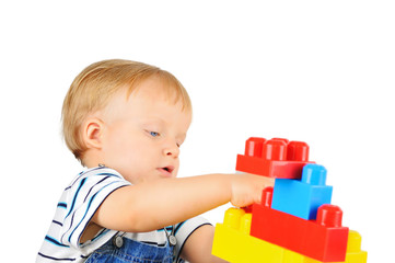 Cute little boy is playing with building blocks