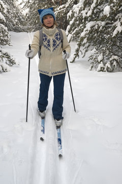 woman skiing in winter forest