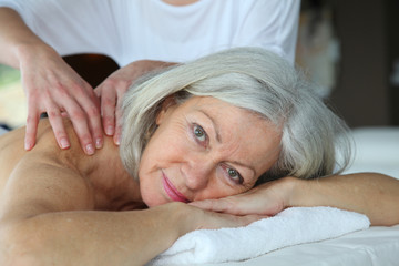 Senior woman having a massage - obrazy, fototapety, plakaty