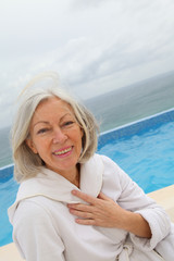 Fototapeta na wymiar Senior woman sitting by pool