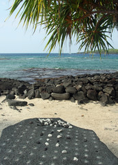 Altes hawaiianisches Spiel am Strand bei Honaunau (Hawaii)