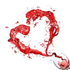 Heart from pouring red wine in glass goblet isolated on white