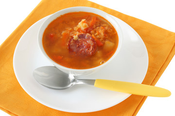 lentil soup with sausages in an white bowl