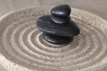 Fototapeta na wymiar Black Stone w piasek ze śladami
