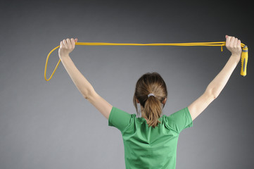 back of girl exercising with jumping rope