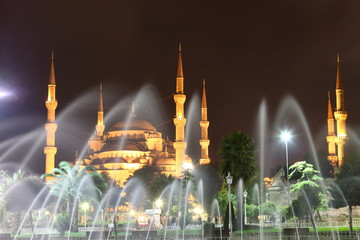 Illuminated Blue Mosque in Istanbul behind fountain at night