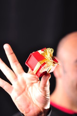 a hand giving red gift box