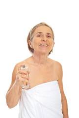 Cheerful senior woman applying perfume