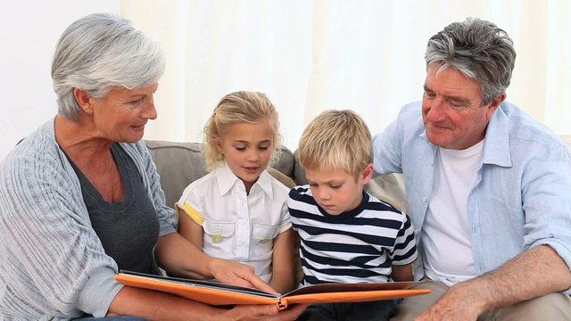 Family looking at a photo album on the sofa