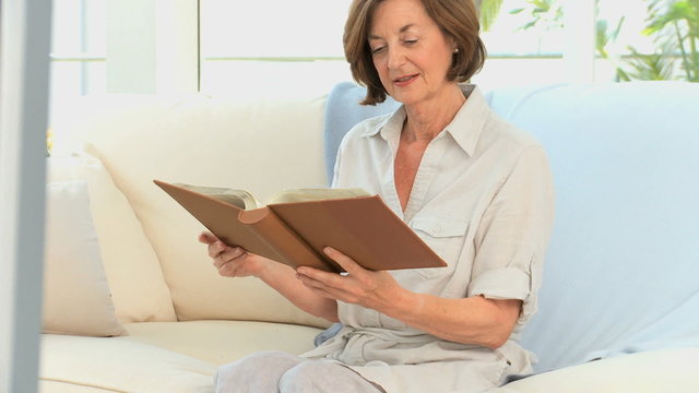 Retired woman looking at a photo album