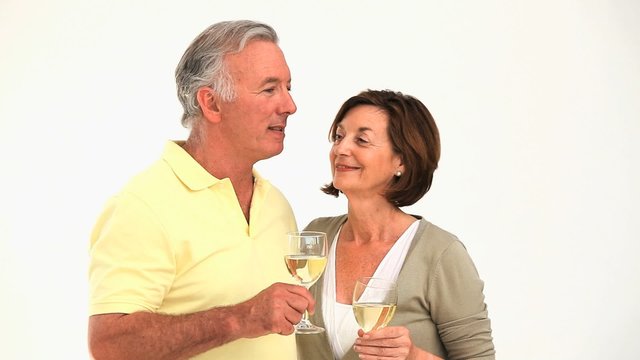 Retired couple celebrating against a white background
