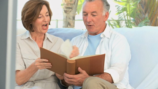 Aged couple looking at a photos album