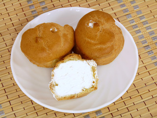 Brewing delicious cake with cream on white plate